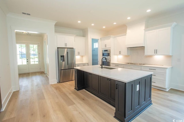 924 Morrall Dr, North Myrtle Beach, SC 29582 - kitchen with appliances with stainless steel finishes, white cabinets, a kitchen island with sink, light countertops, and ornamental molding