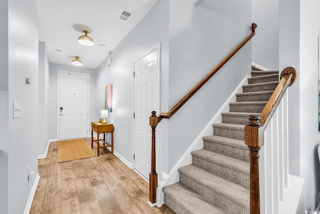 entrance foyer featuring stairs, baseboards, visible vents, and light wood-type flooring