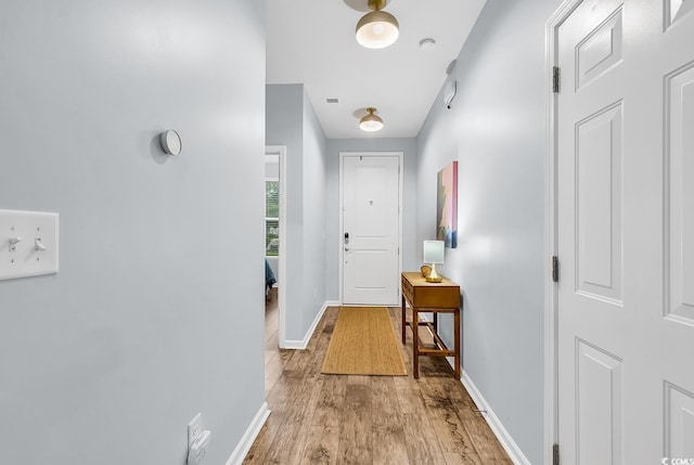 doorway to outside featuring baseboards, light wood-style flooring, and visible vents