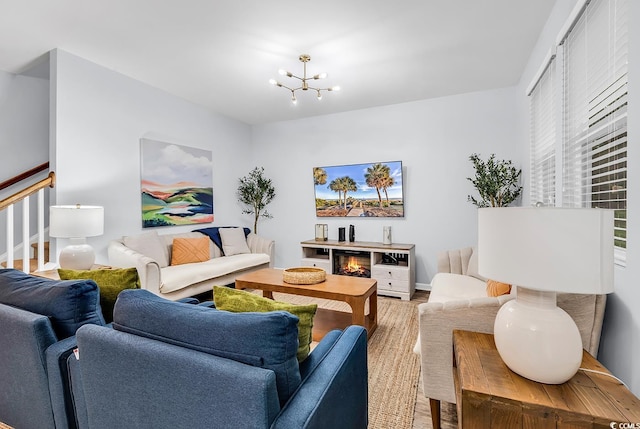 living room featuring an inviting chandelier, baseboards, and wood finished floors