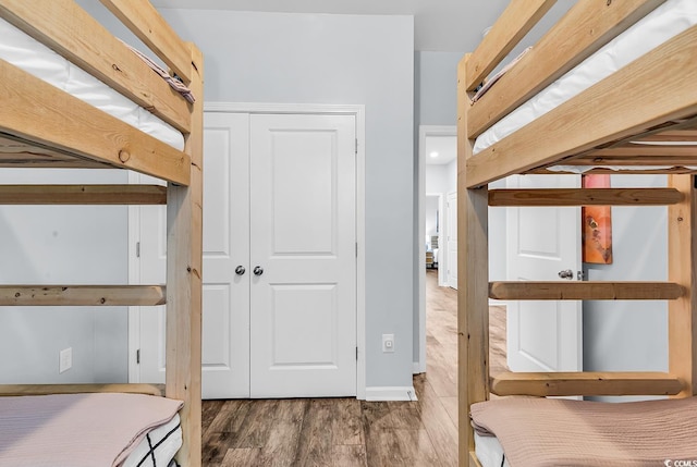 bedroom featuring baseboards, a closet, and wood finished floors
