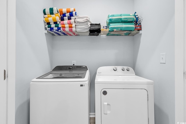 clothes washing area featuring separate washer and dryer and laundry area