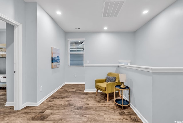 sitting room with recessed lighting, baseboards, visible vents, and wood finished floors