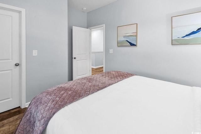 bedroom featuring baseboards and wood finished floors