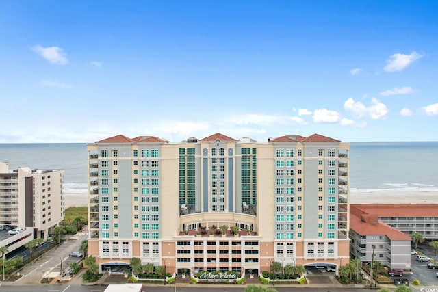 view of building exterior with a water view and uncovered parking