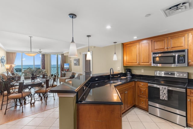 kitchen with dark countertops, a sink, stainless steel appliances, a peninsula, and visible vents