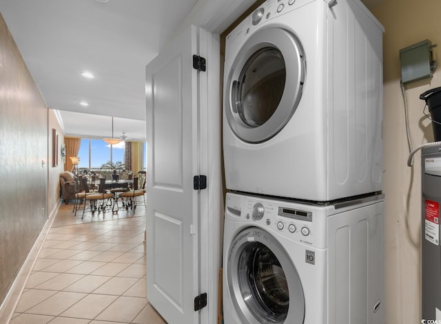 washroom with light tile patterned flooring, stacked washer / drying machine, laundry area, recessed lighting, and baseboards