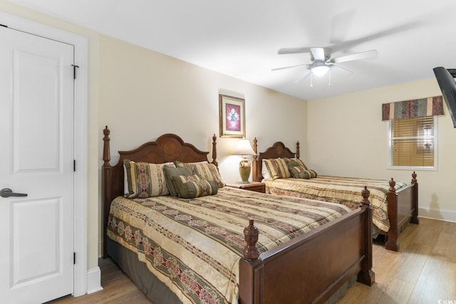 bedroom featuring baseboards, ceiling fan, and light wood-style floors