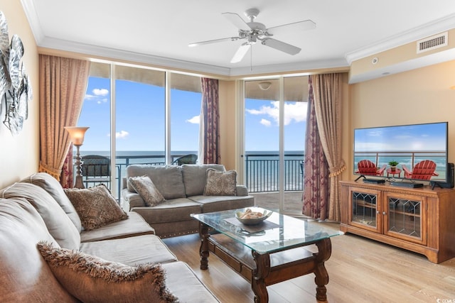 living room with crown molding, floor to ceiling windows, and visible vents