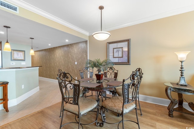 dining room featuring crown molding, baseboards, and visible vents