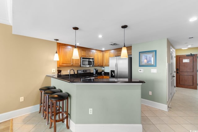 kitchen featuring light tile patterned flooring, dark countertops, stainless steel appliances, recessed lighting, and a peninsula