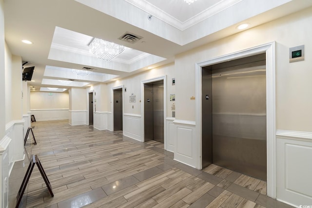 corridor featuring elevator, a chandelier, ornamental molding, and wood tiled floor