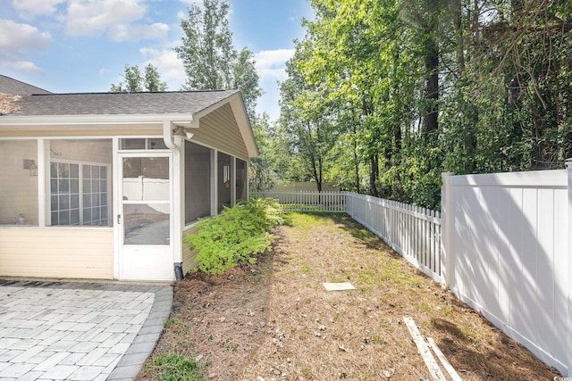 view of yard with a fenced backyard and a sunroom