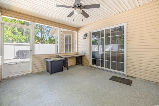 unfurnished sunroom featuring ceiling fan and a wealth of natural light