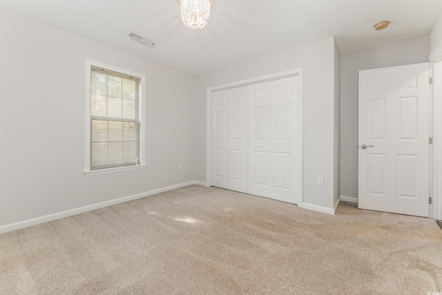 unfurnished bedroom featuring baseboards, carpet, a closet, and visible vents