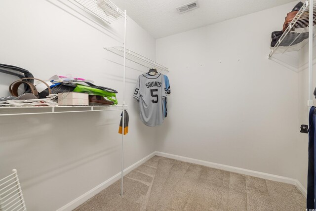 walk in closet with light carpet and visible vents