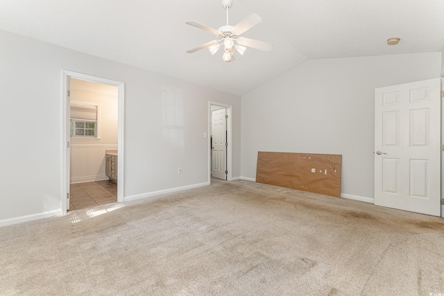 unfurnished bedroom featuring baseboards, carpet flooring, and vaulted ceiling