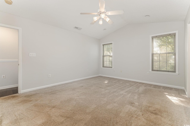 unfurnished room featuring visible vents, a ceiling fan, lofted ceiling, and light carpet
