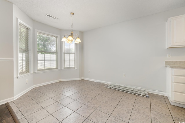 unfurnished dining area featuring a chandelier, baseboards, visible vents, and light tile patterned flooring