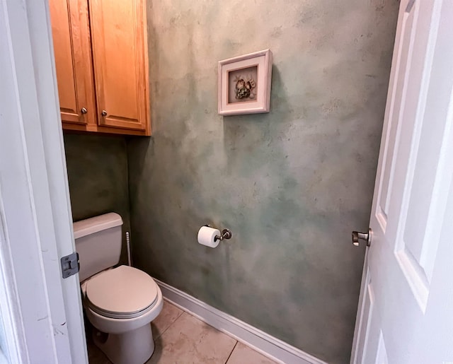 bathroom with baseboards, tile patterned floors, and toilet
