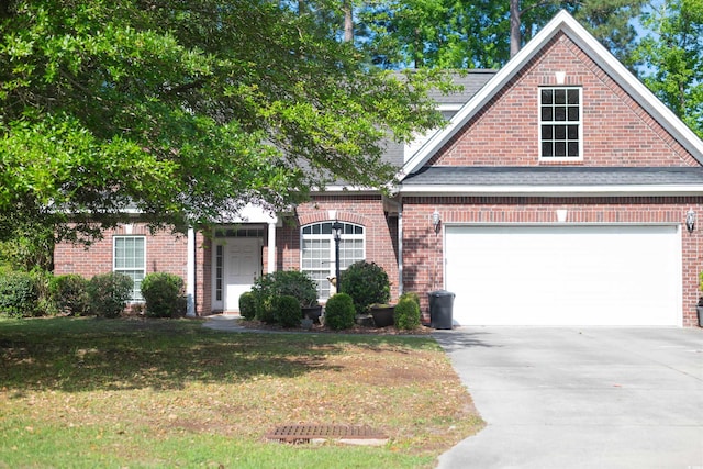 traditional-style house with brick siding, a front lawn, and driveway