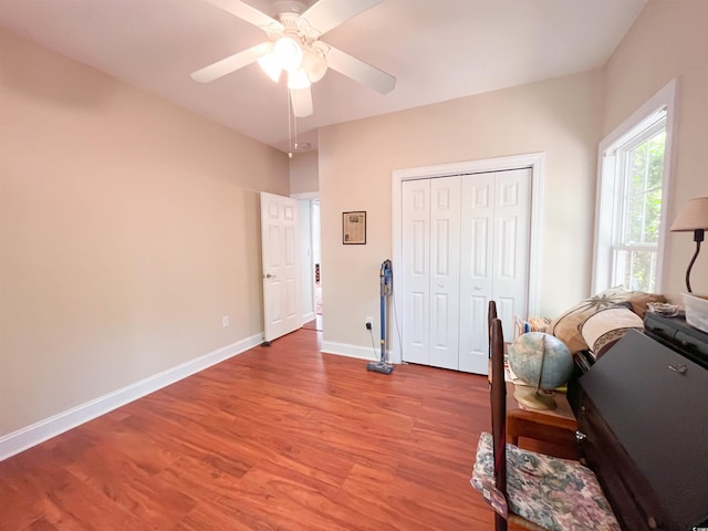 office space featuring baseboards, a ceiling fan, and wood finished floors