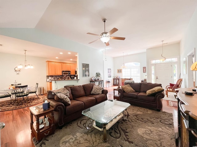 living room with recessed lighting, ceiling fan with notable chandelier, and wood finished floors