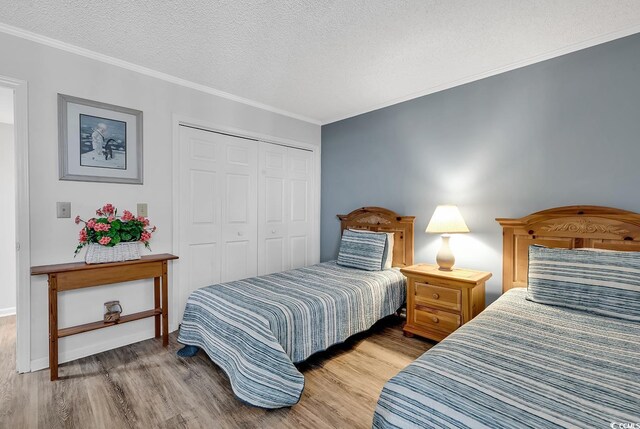 1581 S Waccamaw Dr Unit 302, Garden City Beach, SC 29576 - bedroom with a closet, a textured ceiling, crown molding, and wood finished floors