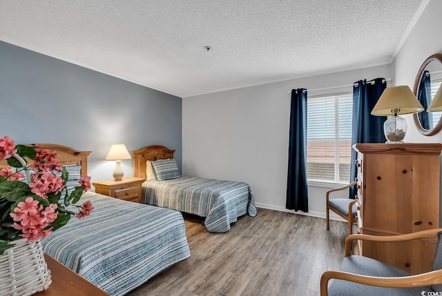 1581 S Waccamaw Dr Unit 302, Garden City Beach, SC 29576 - bedroom with crown molding, baseboards, a textured ceiling, and wood finished floors