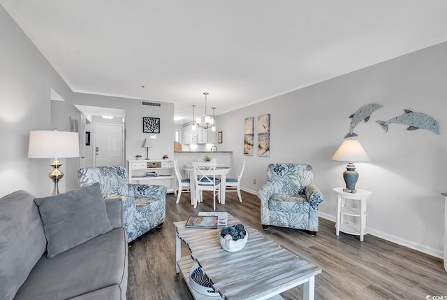 1581 S Waccamaw Dr Unit 302, Garden City Beach, SC 29576 - living area featuring an inviting chandelier, baseboards, ornamental molding, and dark wood-style flooring