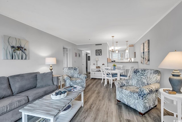 1581 S Waccamaw Dr Unit 302, Garden City Beach, SC 29576 - living area featuring an inviting chandelier, ornamental molding, wood finished floors, and visible vents
