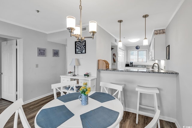 1581 S Waccamaw Dr Unit 302, Garden City Beach, SC 29576 - dining space featuring baseboards, dark wood finished floors, ornamental molding, and visible vents