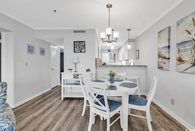 1581 S Waccamaw Dr Unit 302, Garden City Beach, SC 29576 - dining room featuring a notable chandelier, visible vents, ornamental molding, and wood finished floors