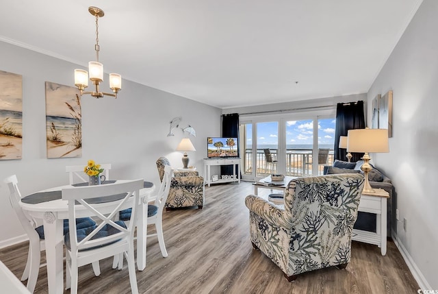 1581 S Waccamaw Dr Unit 302, Garden City Beach, SC 29576 - living room with baseboards, crown molding, wood finished floors, and a notable chandelier