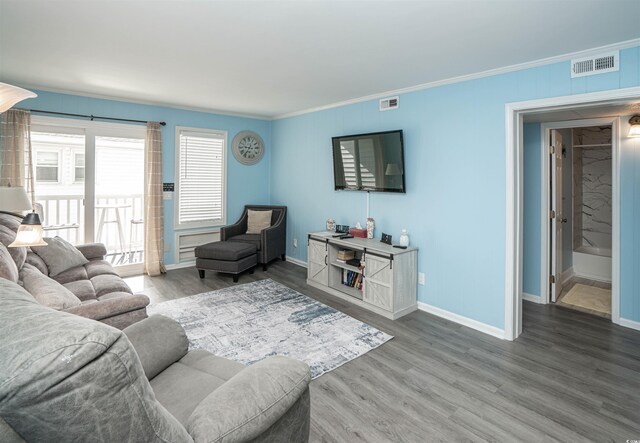 living area with crown molding, baseboards, wood finished floors, and visible vents