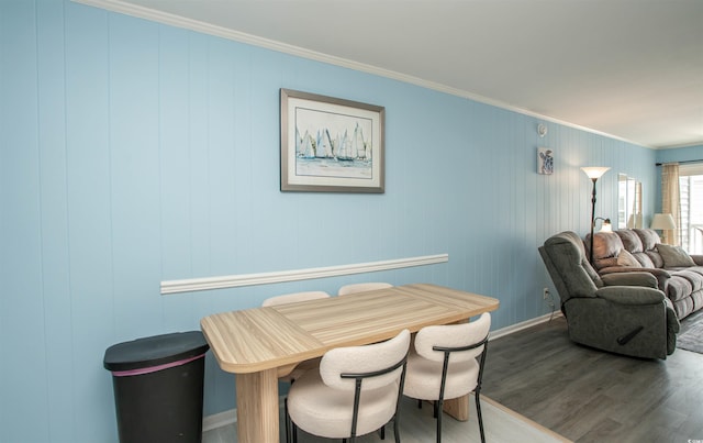 dining area with baseboards, ornamental molding, and wood finished floors