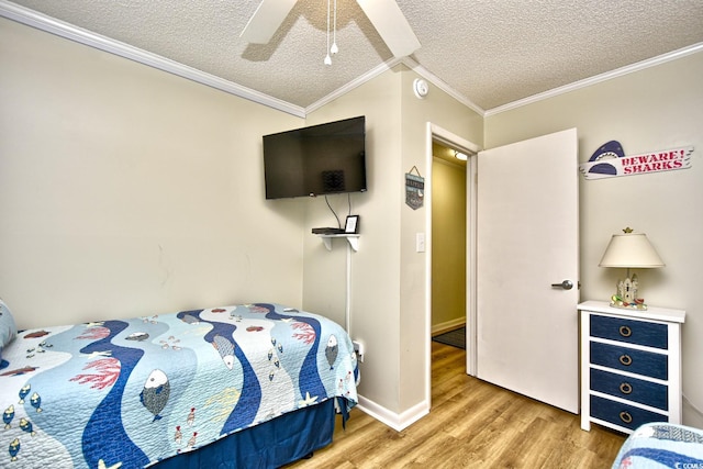 bedroom featuring ornamental molding, a textured ceiling, ceiling fan, and wood finished floors
