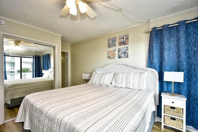 bedroom with a textured ceiling, ceiling fan, ornamental molding, and wood finished floors
