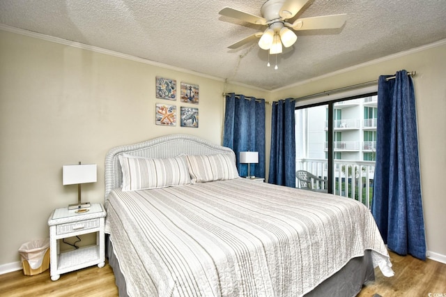 bedroom featuring a textured ceiling, ornamental molding, and wood finished floors