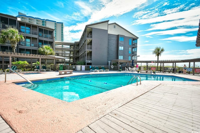 community pool with fence and a patio area