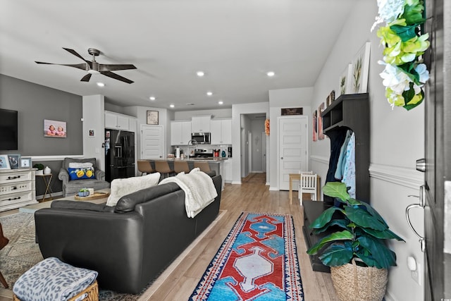 living area with light wood-style floors, a ceiling fan, and recessed lighting