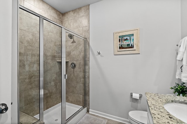 bathroom featuring baseboards, a stall shower, toilet, and vanity