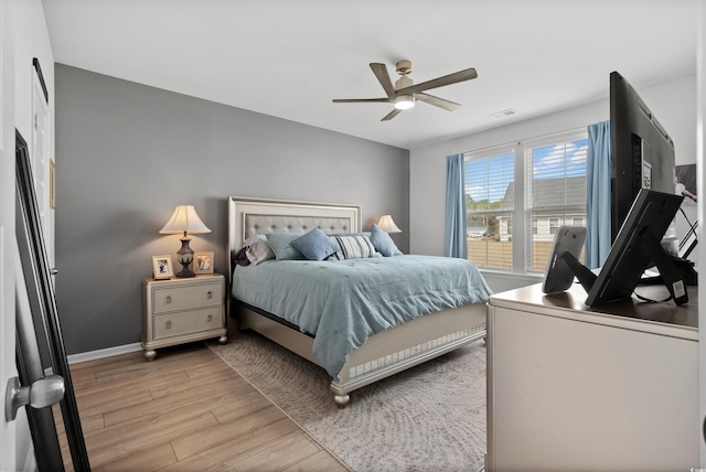 bedroom featuring baseboards, visible vents, ceiling fan, and light wood-type flooring