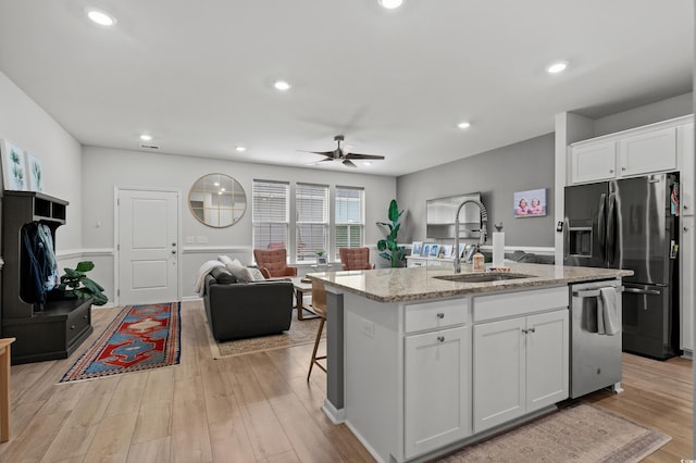 kitchen with ceiling fan, a sink, dishwasher, open floor plan, and fridge with ice dispenser
