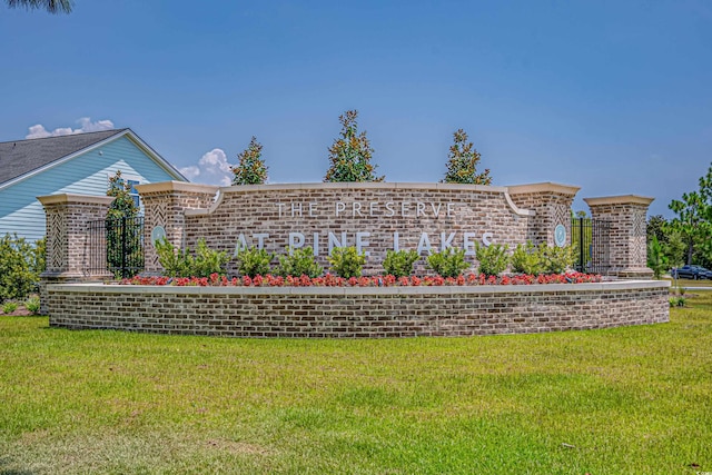community / neighborhood sign featuring a yard