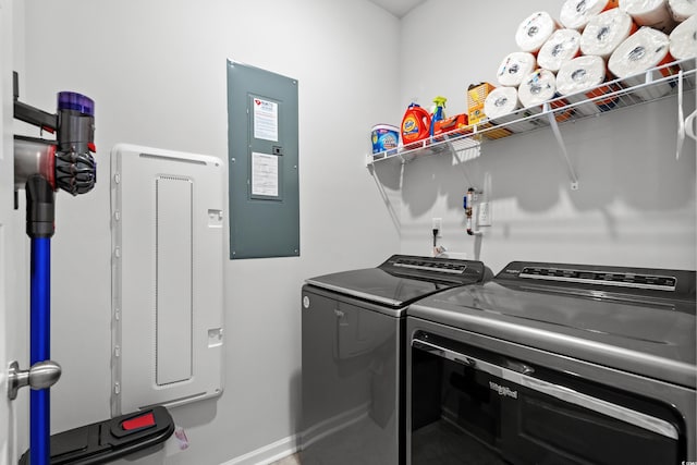 washroom featuring laundry area, baseboards, electric panel, and separate washer and dryer