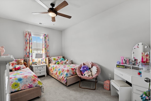bedroom featuring a ceiling fan, visible vents, and light carpet