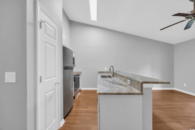 1260 White Tree Ln Unit F, Myrtle Beach, SC 29588 - kitchen with a sink, light wood-style floors, freestanding refrigerator, a ceiling fan, and a peninsula