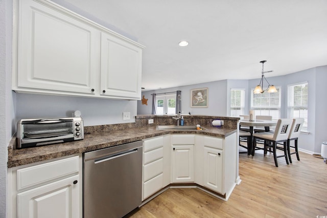 1097 Stoney Falls Blvd, Myrtle Beach, SC 29579 - kitchen featuring stainless steel dishwasher, dark countertops, light wood-style flooring, a peninsula, and white cabinetry