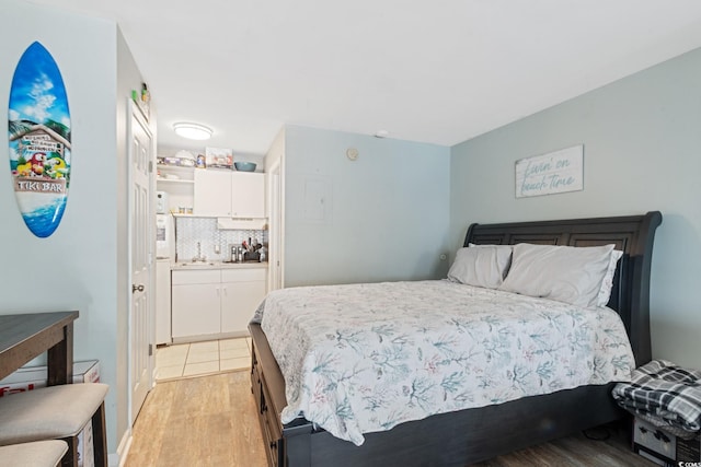 bedroom featuring light wood finished floors and a sink
